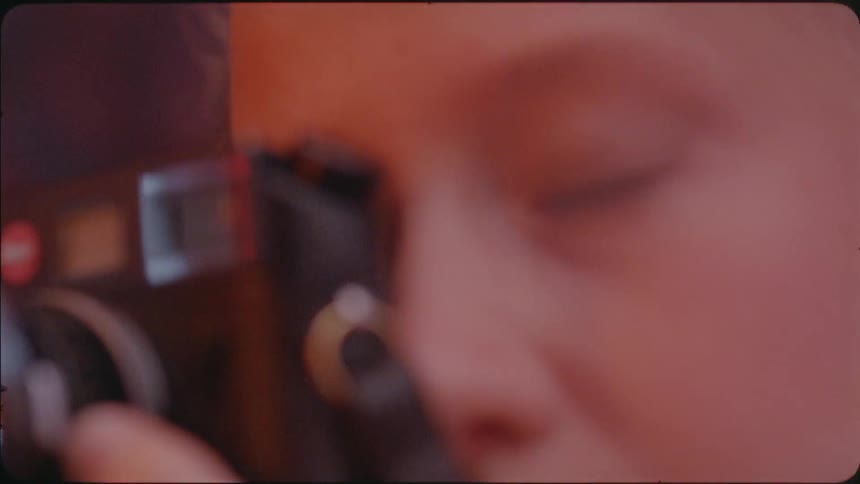 A woman holds a camera up to take a photograph