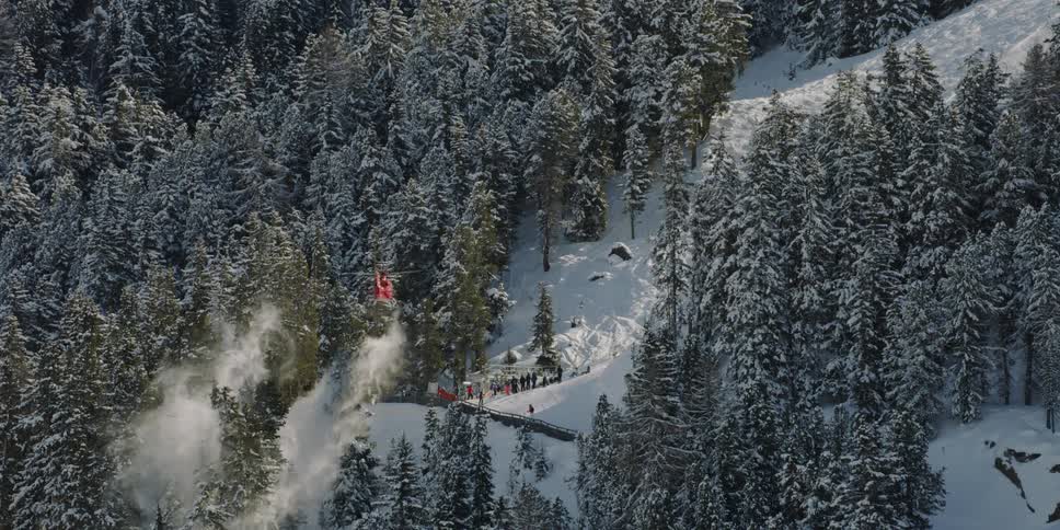 A helicopter flies over a snowy forest