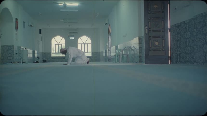 Man kneels and prays in a mosque
