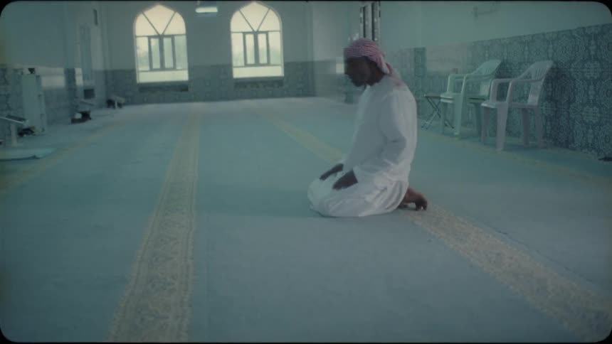 Man kneels on the floor and leans over to kiss it