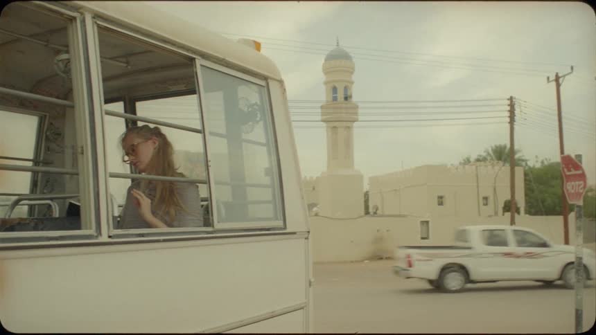 A woman is sitting in the back of the bus