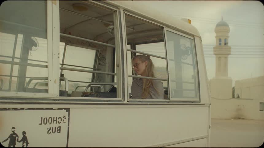 Woman sits on a small white bus