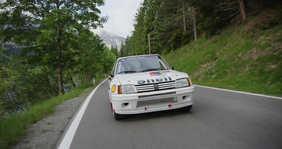 Person driving race car on mountain highway during the day