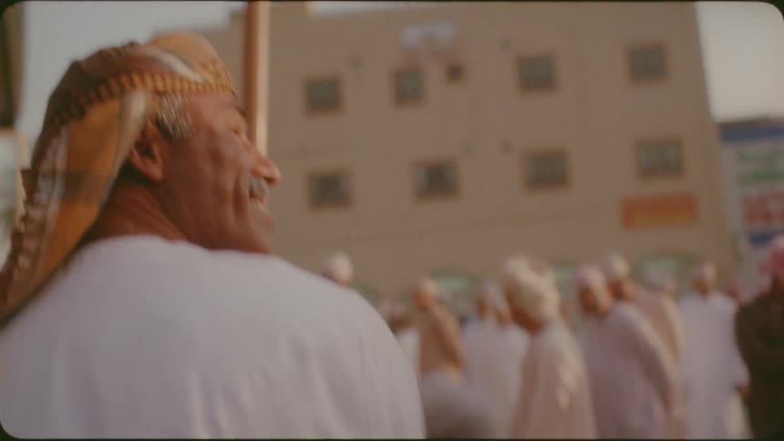 Man and woman smile and walk through a crowded village