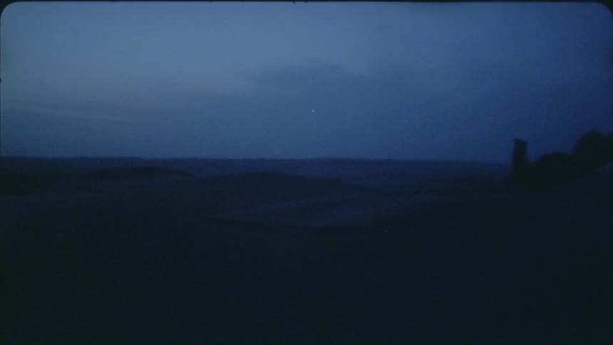 A scarf is blowing in the air on windy night after sunset