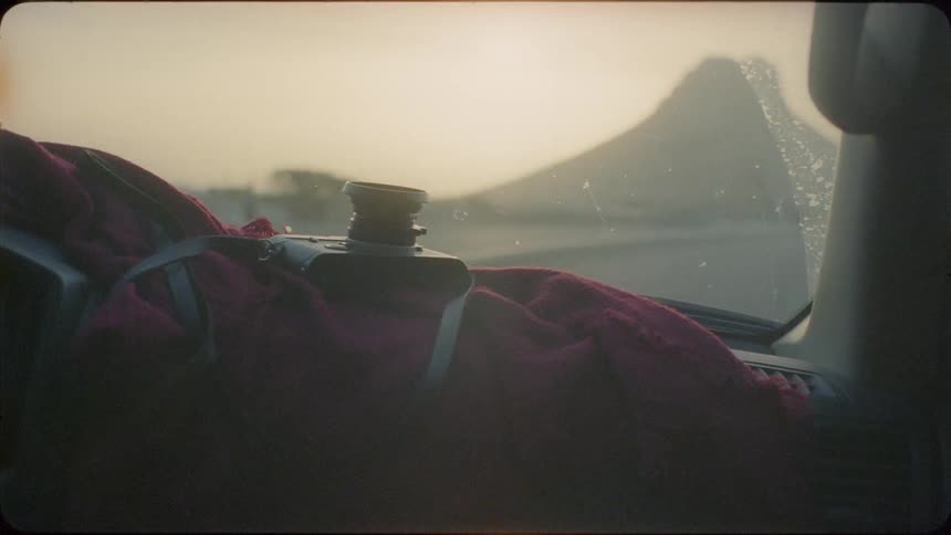 A vehicle is turning around the road at sunset