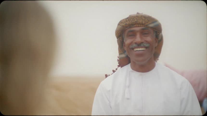 A middle eastern man talks with a blond haired woman