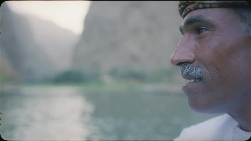 A man smiles by the water