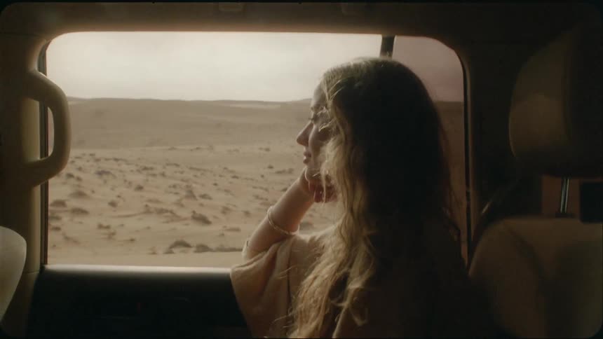 Woman rides in a car in a desert