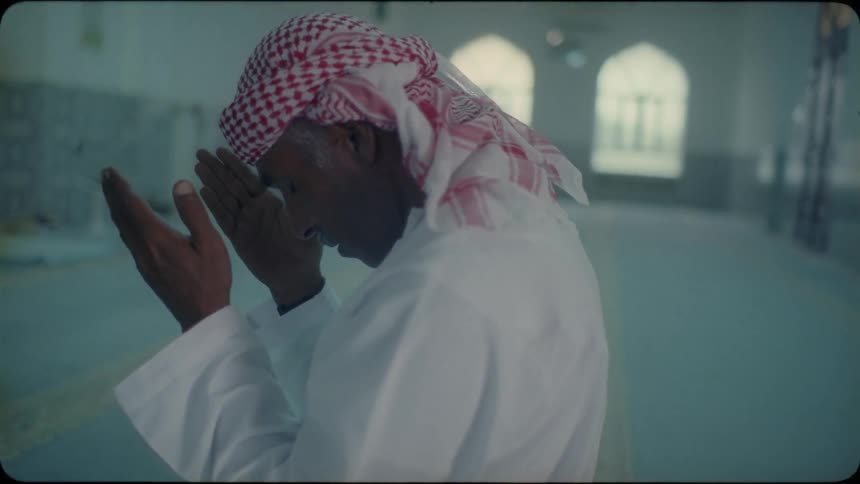 A middle eastern man prays in a mosque