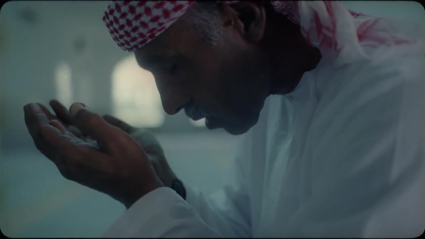 Man holds his hands facing upwards as he prays