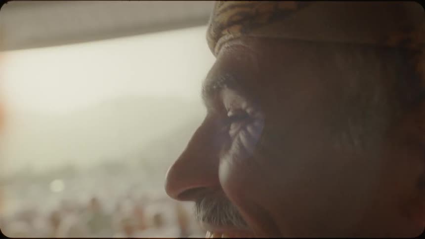 Man smiles and looks out across a crowd