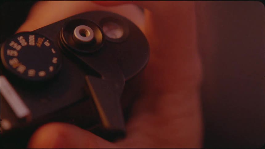 A hand pushes a lever on a camera