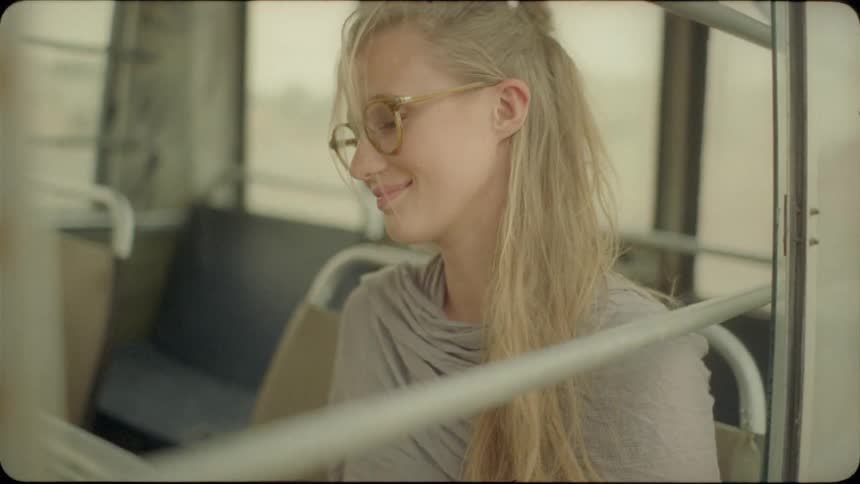 A blond haired woman sits in the back of a van