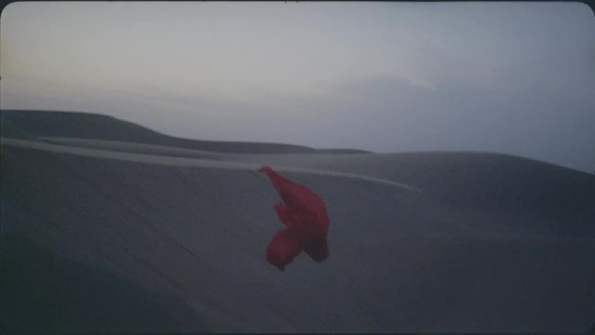 A red veil flies over the sand dunes