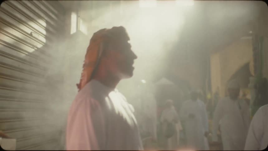 Smoke floats around a man as he stands in a market