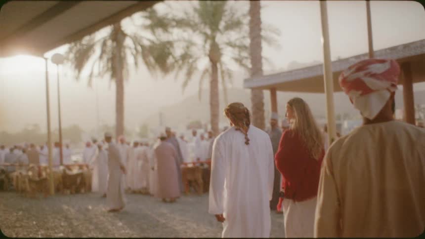 Man and woman walk near an outdoor market