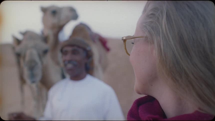 A blond haired woman talks to a middle eastern man