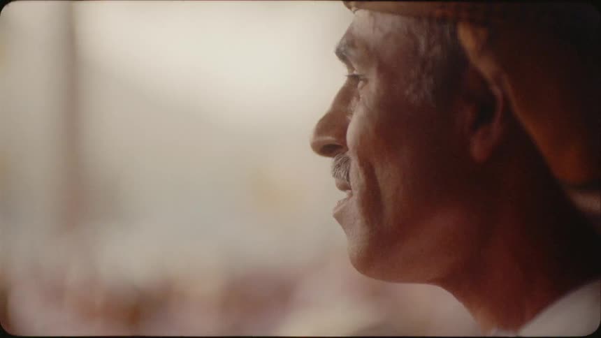 Man wearing a turban looks around at a crowd