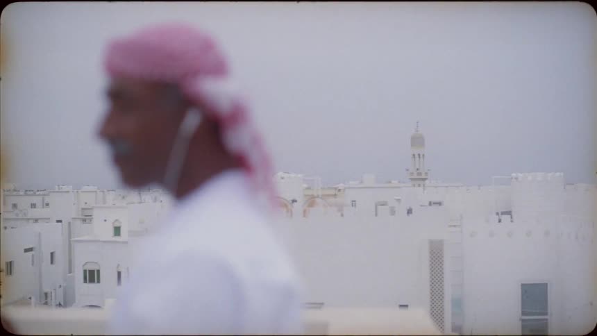 Smiling man stands on a rooftop
