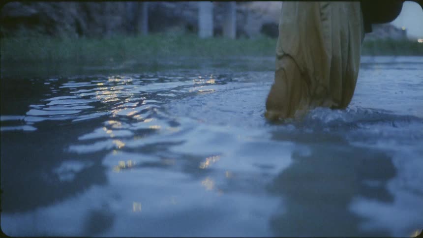 Person walks through a pond in the evening