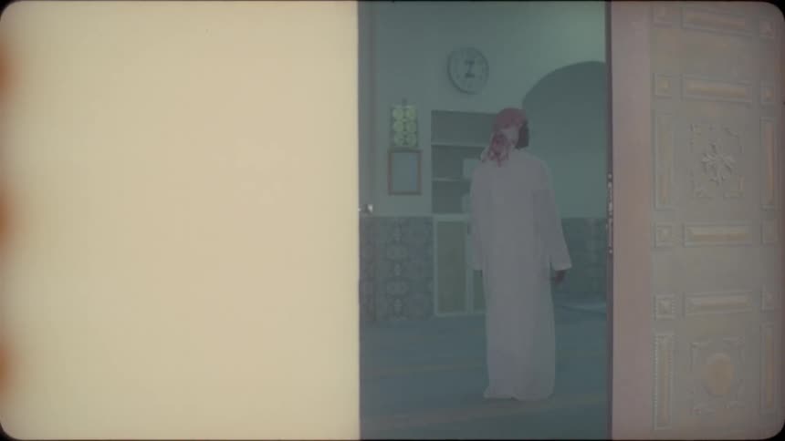 Man in robe and turban stands up