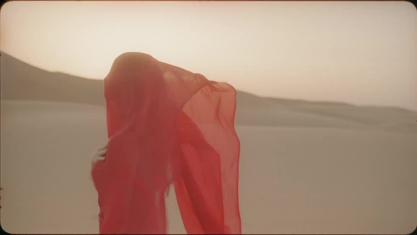 Red veil covering a woman blows in the breeze