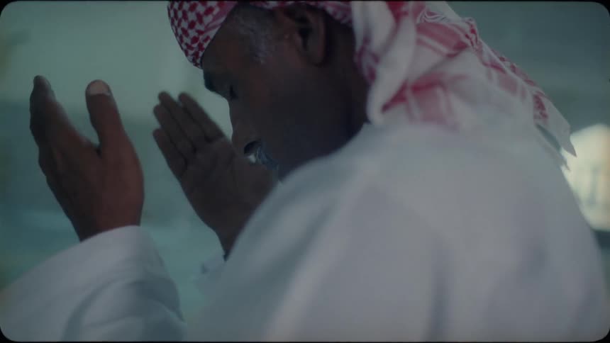 Man kneels and wipes hands on his face
