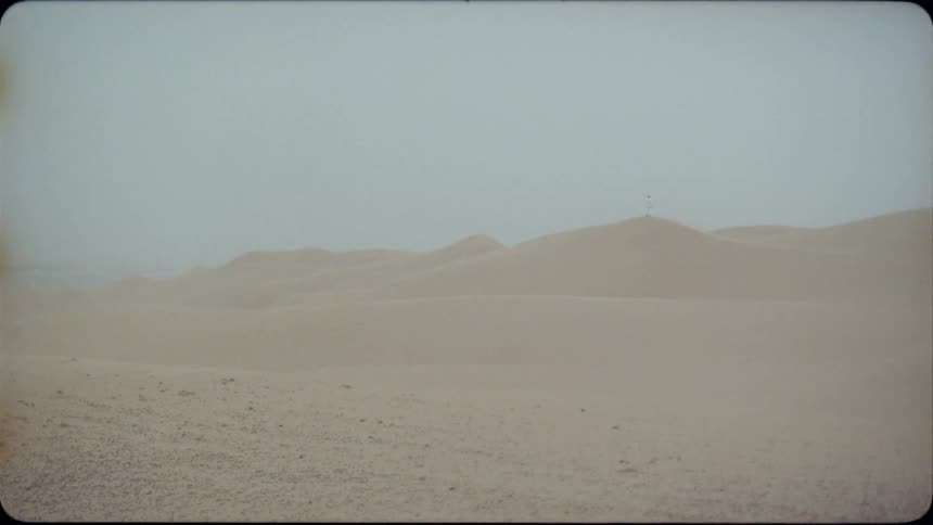 Sand dunes cover a desert landscape