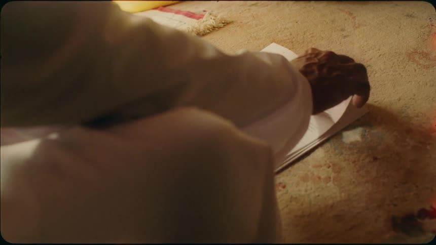 A man sits on the floor and reads a book