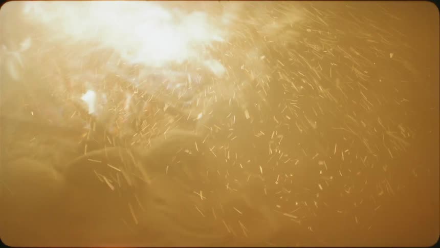 The wind blows embers from a small campfire