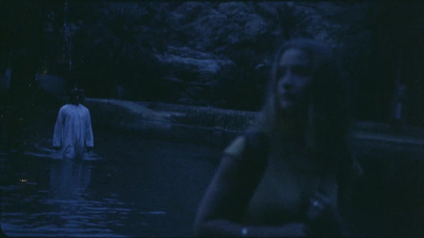 A man and woman wade through waist deep water