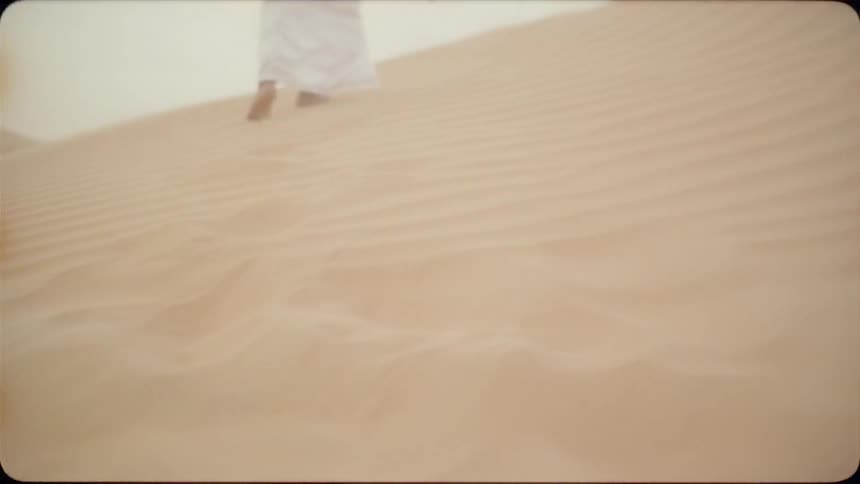 Man walks through the desert in his bare feet