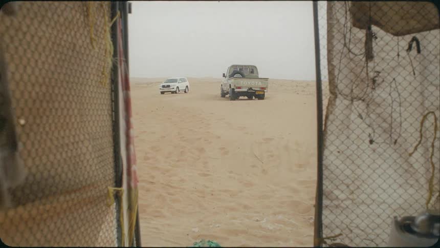 Several vehicles sit in the desert