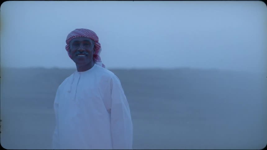 The man is standing in the desert smiling