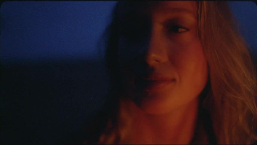 Woman's face illuminated by firelight at night