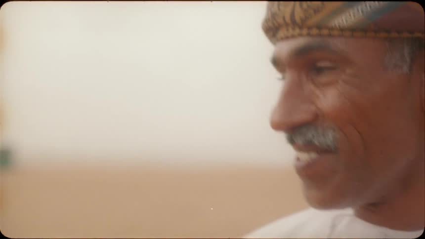 Man standing in the desert smiles and nods his head