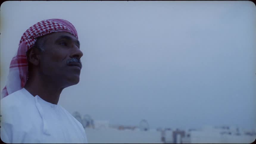 The man looks up towards the cloudy sky