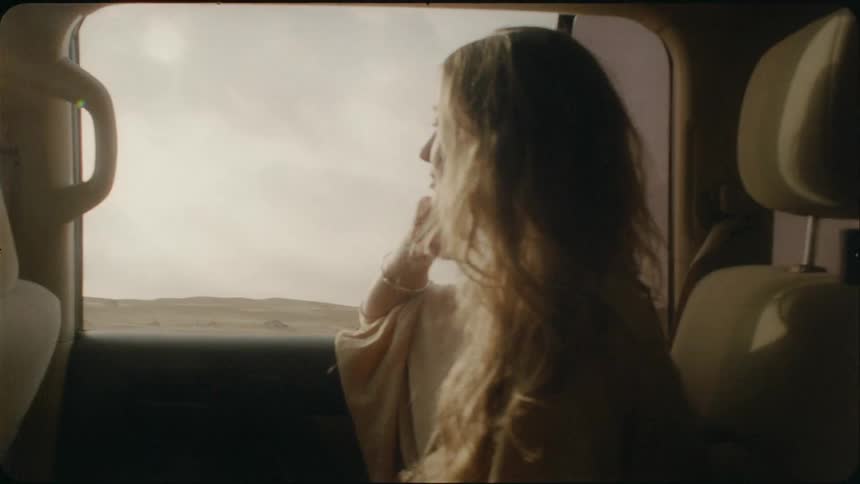 A woman rides in the back of a van
