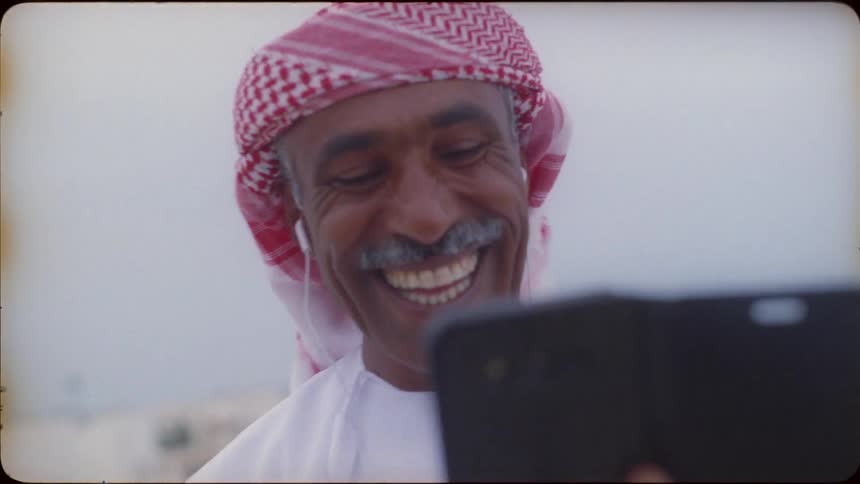 Man laughs as he looks at his cellphone