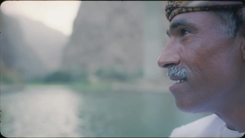 Man smiles as he stands near the river