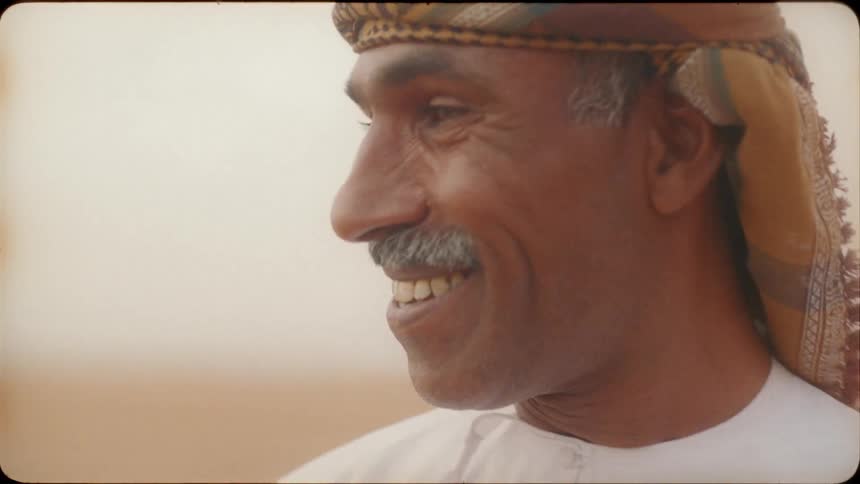 Man standing outside desert smiles and nods his head