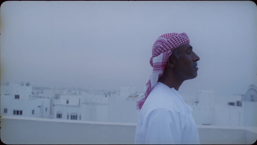 A man looks around on the roof on a windy day