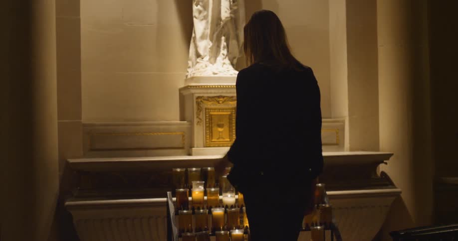 A woman lighting a candle in church