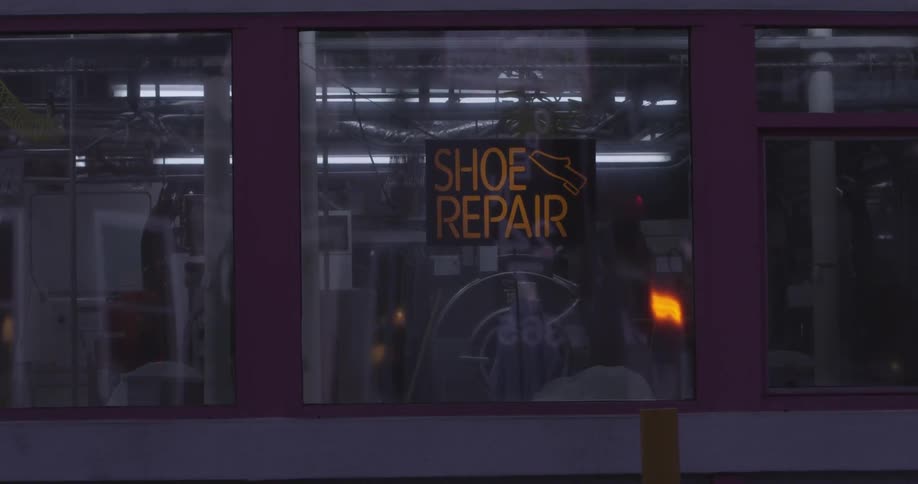 Reflections of cars in a shoe repair store window