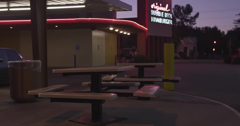 Restaurant can be seen with outdoor tables at sunset