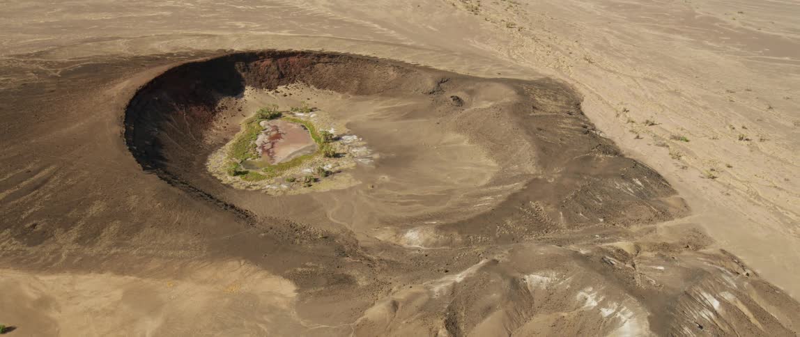 Rocks sit in the middle of a large crater in the desert