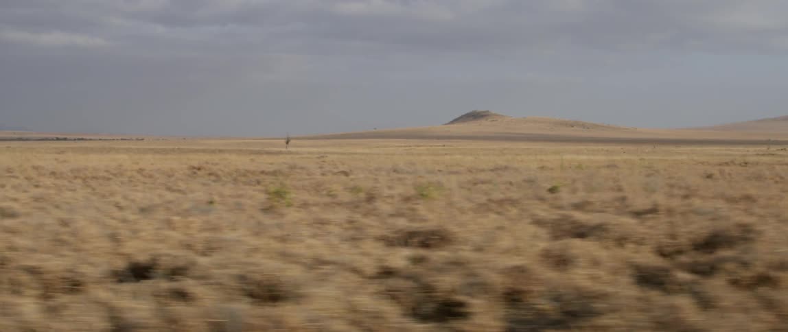 Traveling past a desert landscape on a cloudy day