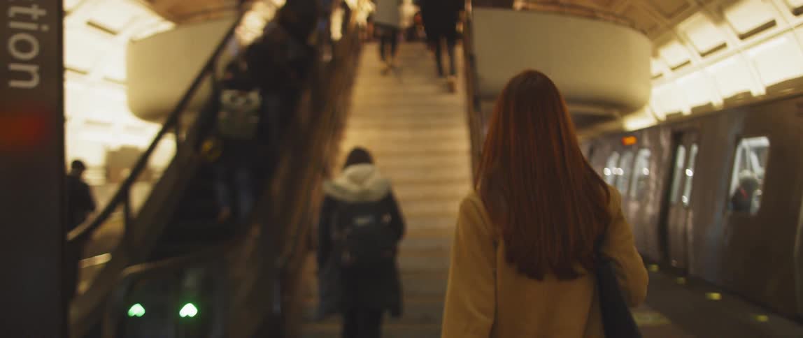 Woman with a shoulder bag walks in the subway station