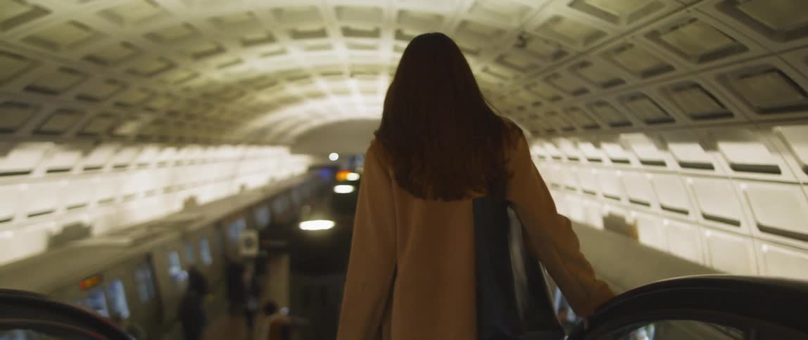 Woman walks down a staircase in a subway